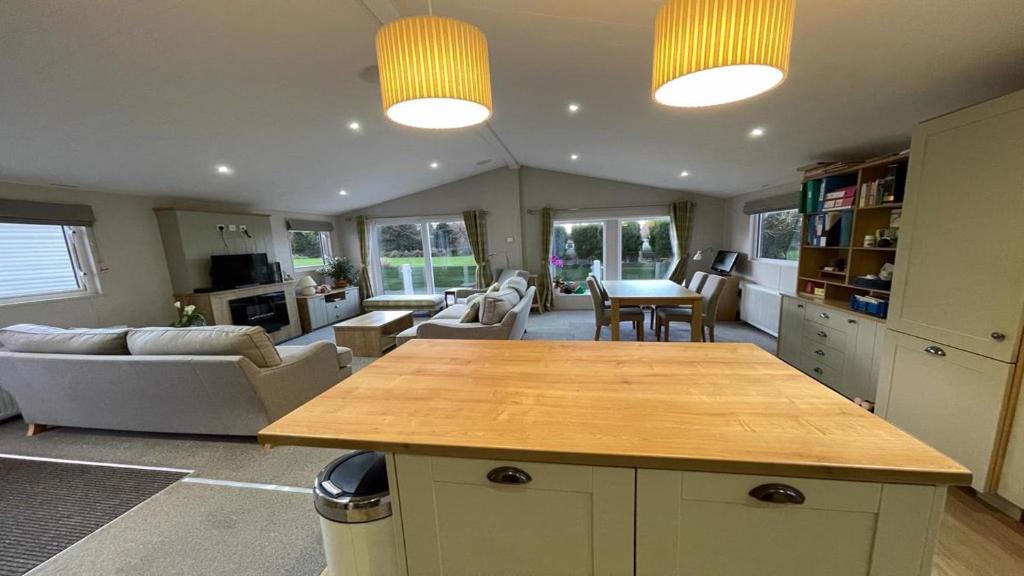cocina y sala de estar con mesa y sillas en 42 Woodland Walk Pevensey Bay Holiday Park sleeps 6, en Pevensey