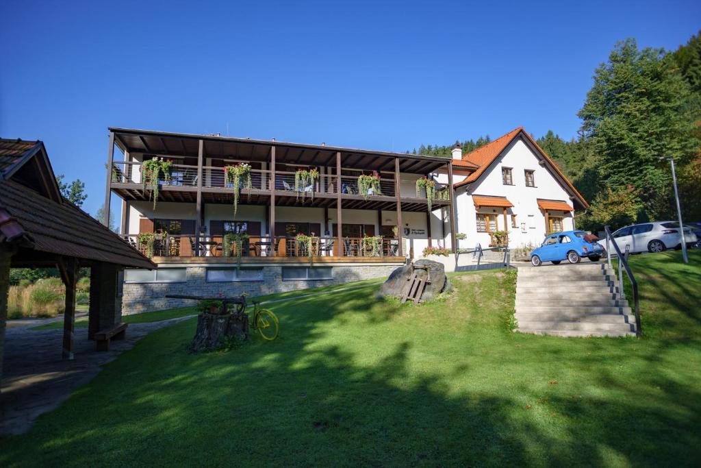 a large house with a balcony and a yard at Hotel a restaurace U Vychopňů in Vsetín