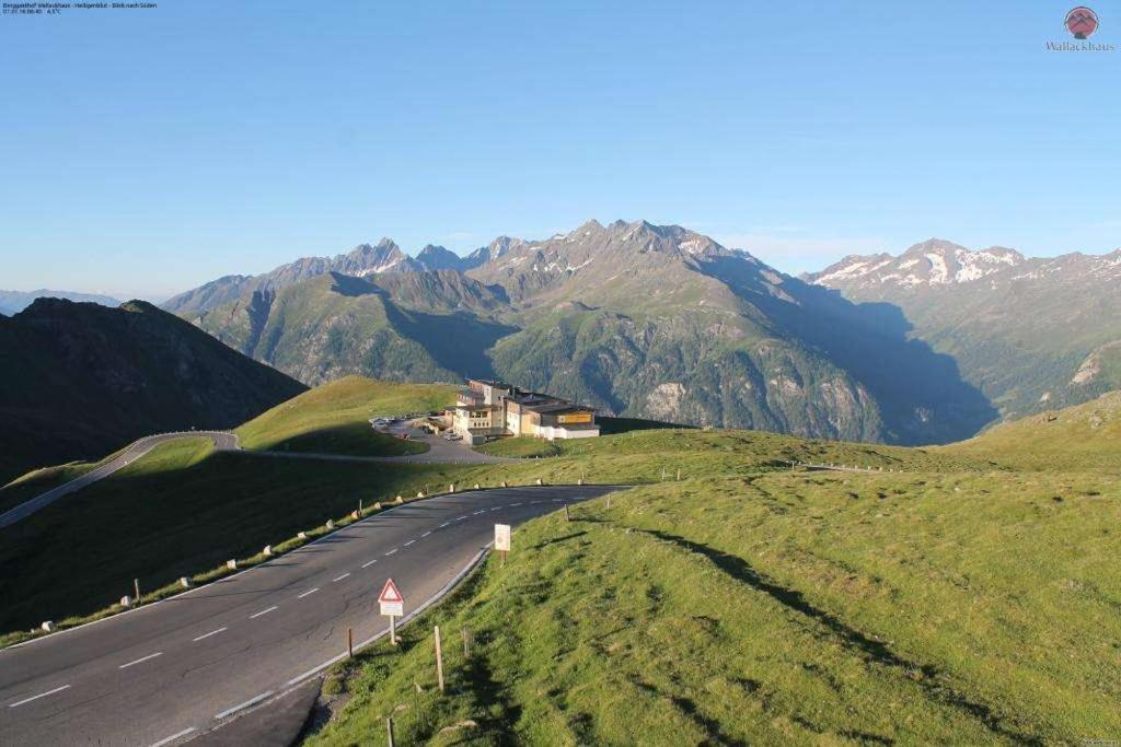 een weg op een heuvel met bergen op de achtergrond bij Wallackhaus RegioJet Hotels in Heiligenblut