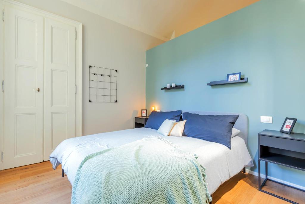 a bedroom with a bed and a blue wall at Top Living Apartments - Torino Centro in Turin
