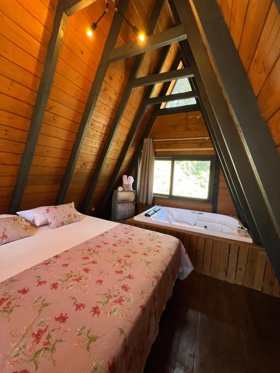 a room with two beds and a bath tub in a attic at URUBICI - Cabana da Montanha in Mundo Novo