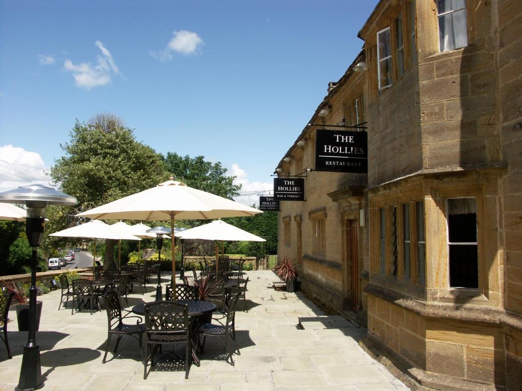 an outdoor patio with tables and chairs and umbrellas at Hollies Hotel in Martock
