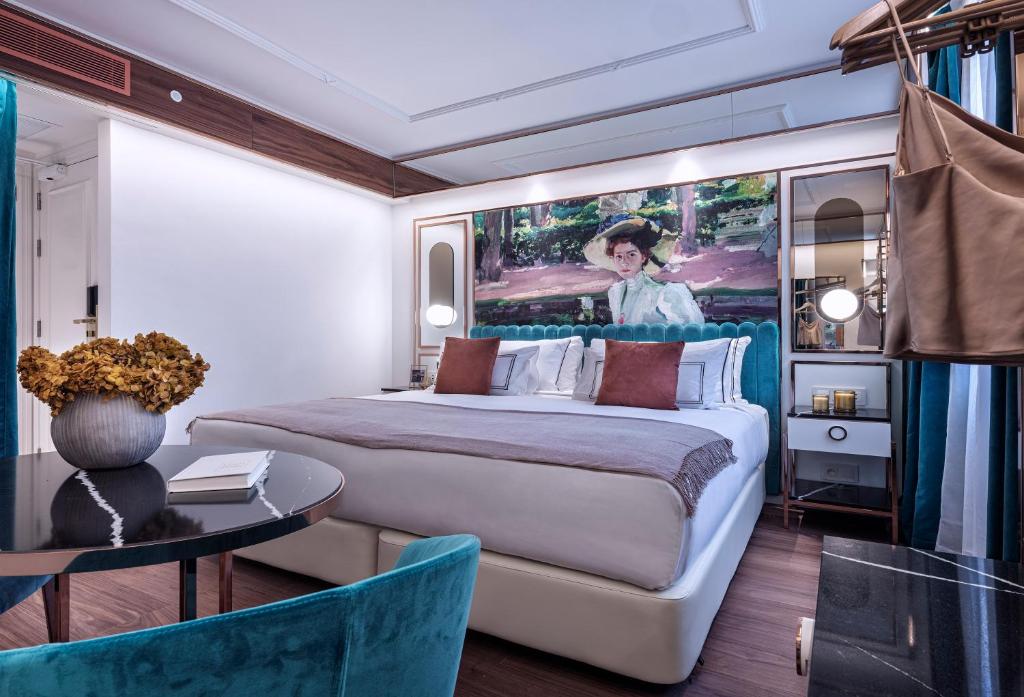 a bedroom with a large bed with a painting on the wall at Maison Colbert Member of Meliá Collection in Paris