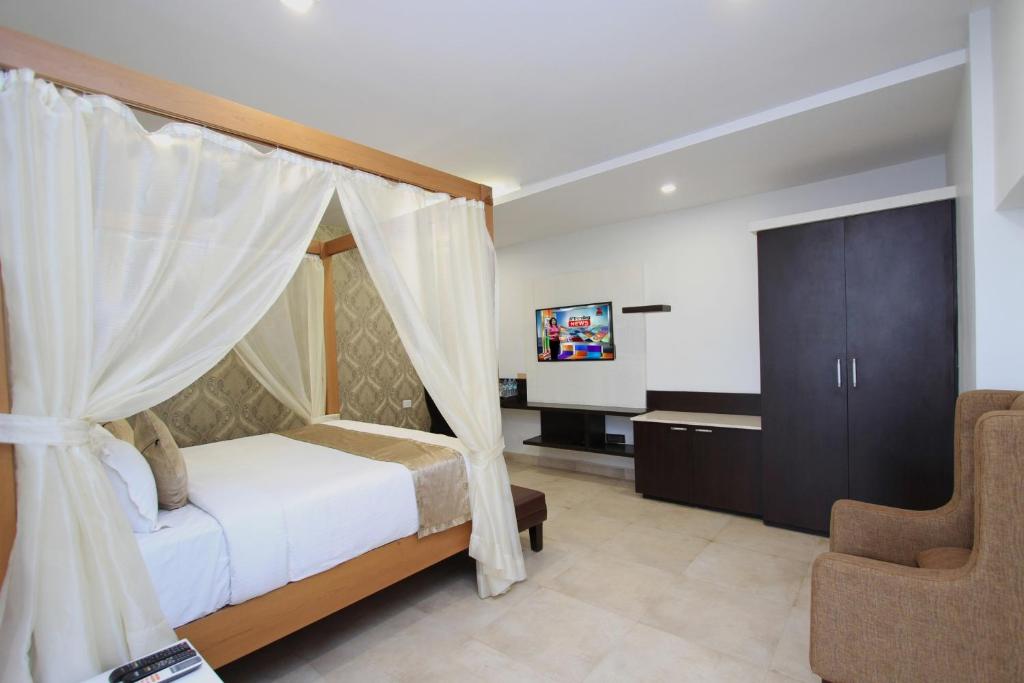 una camera con letto a baldacchino e sedia di Ambaari hotel a Mysore