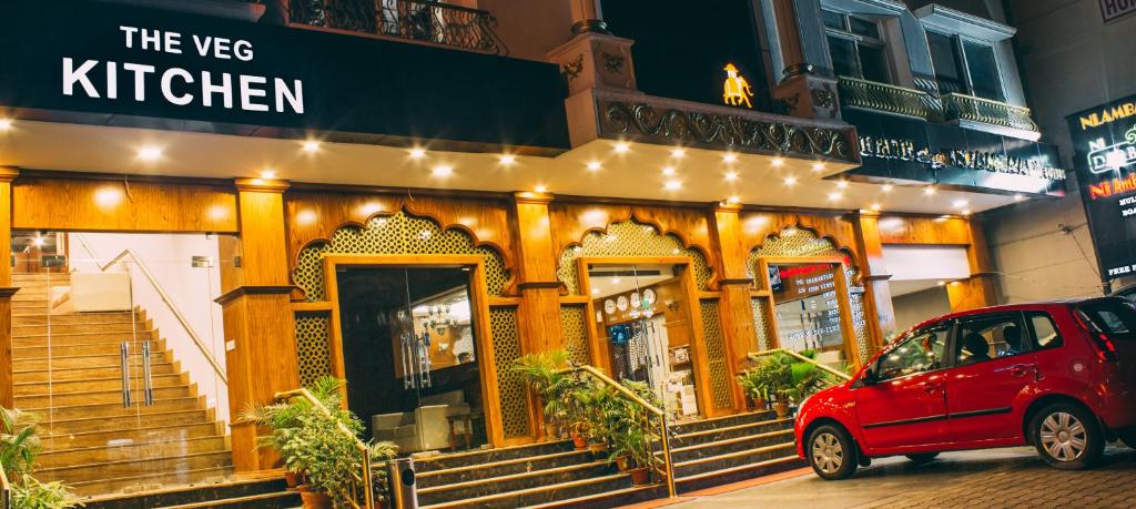 un'auto rossa parcheggiata davanti a un ristorante di Ambaari hotel a Mysore
