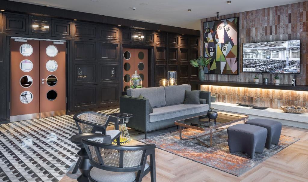 a living room with a couch and chairs at TITANIC Comfort Kurfürstendamm in Berlin