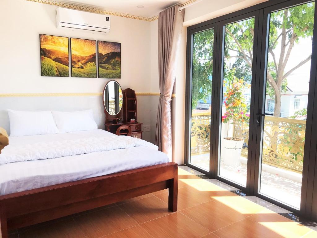 a bedroom with a bed and a large window at Khách Sạn Mỹ Hằng in Soc Trang