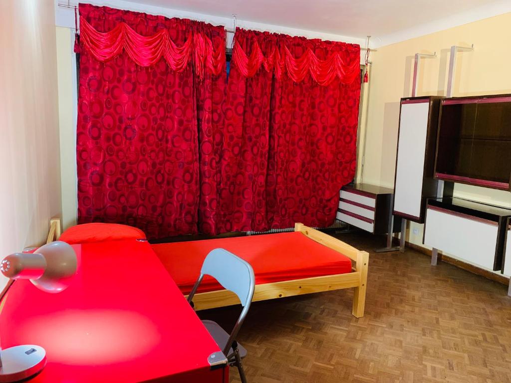 une chambre rouge avec une table et un rideau rouge dans l'établissement Confortable-House, à Vitry-sur-Seine