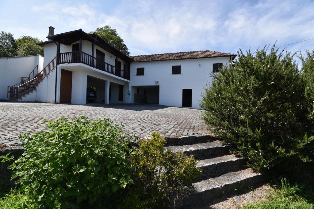 une grande maison blanche avec un escalier en face de celle-ci dans l'établissement Travessa Das Quintas, à Baiões