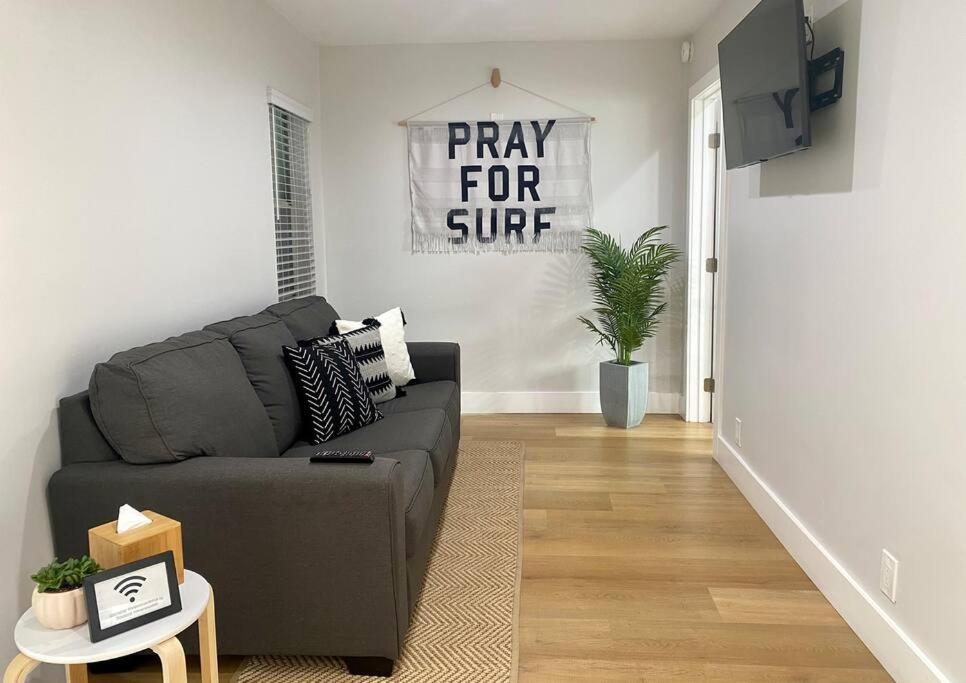 a living room with a couch and a pray for cure sign at Steps To The Beach, Main Street and Pacific City - 2BR in Huntington Beach