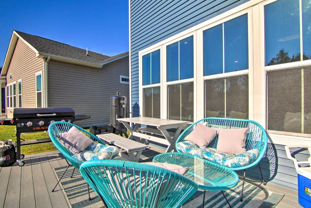 a patio with three chairs and a table and a grill at Modern Lewes Home with Deck, Grill and Pond View! in Lewes