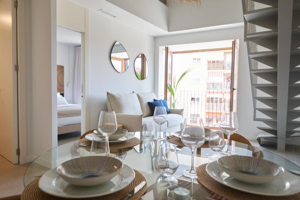 uma sala de estar com uma mesa de vidro com copos de vinho em Slow Home Apartments em Valência