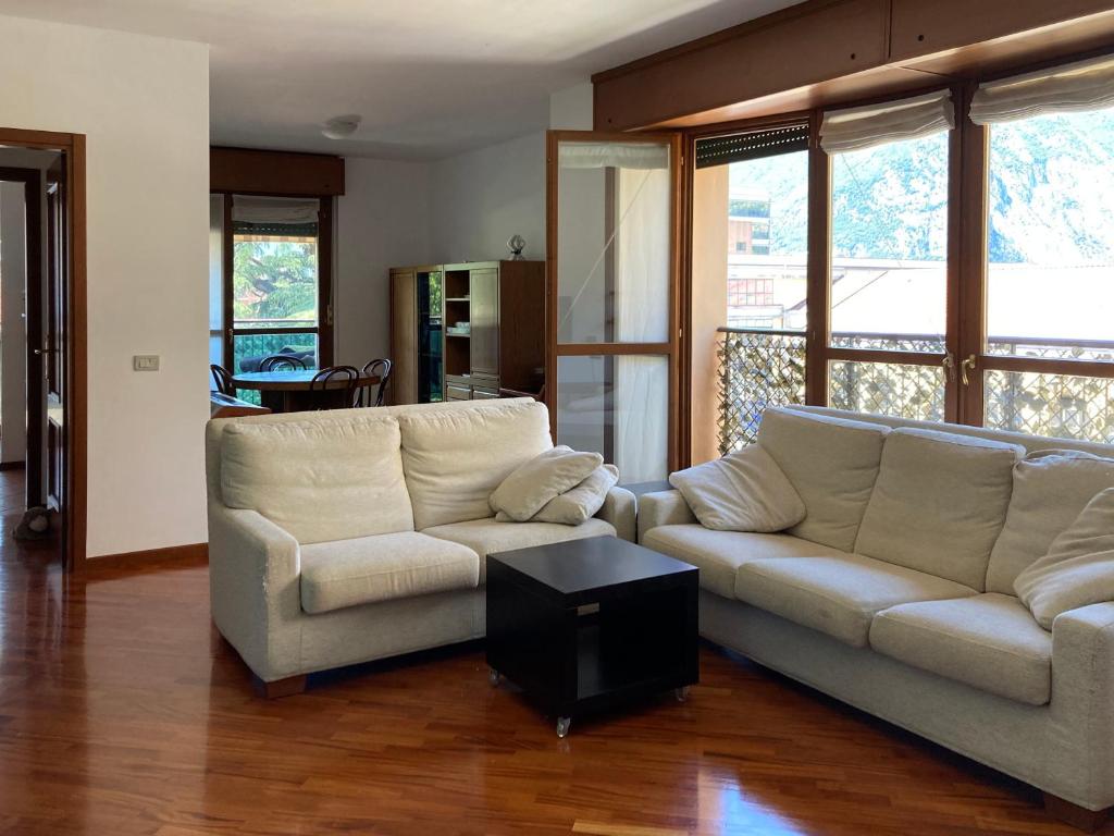 Sala de estar con 2 sofás y mesa en Spacious bright apartment near city center and Como lake with air conditioning, en Lecco