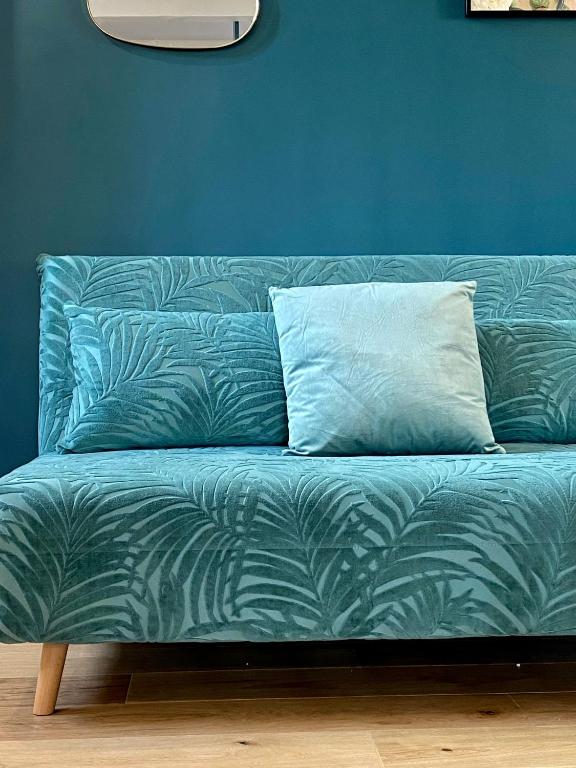a blue couch with a pillow on a blue wall at Paradise Penthouse Suite Amazing View in Rome