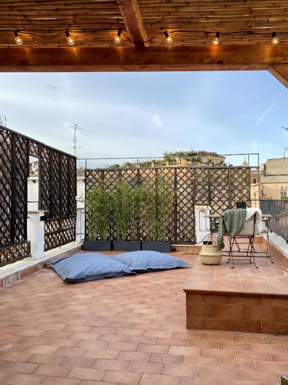 a large patio with a couch and a chair on a roof at Paradise Penthouse Suite Amazing View in Rome