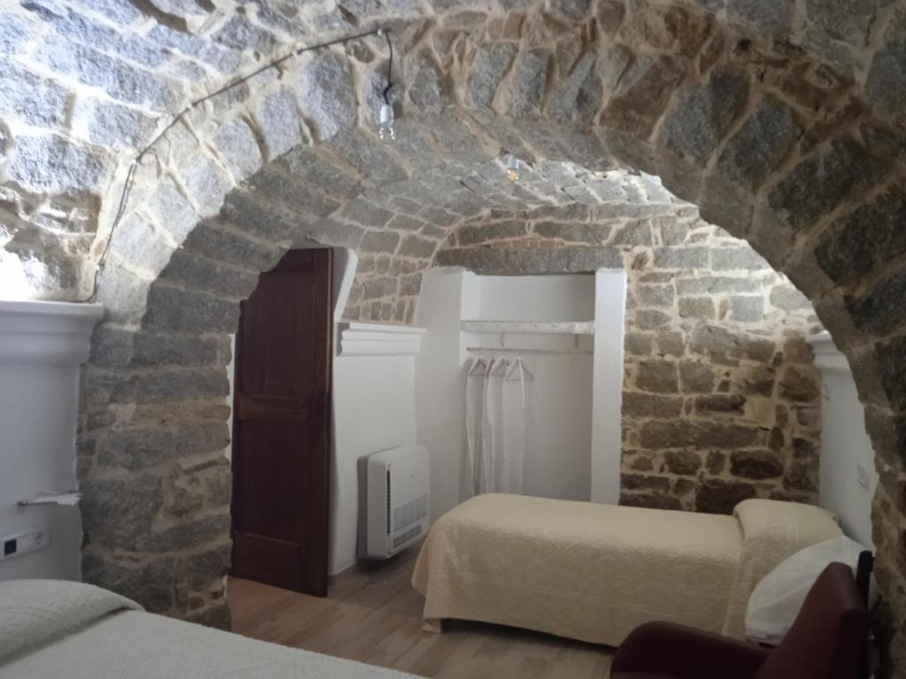 Cette chambre comprend 2 lits et un mur en briques. dans l'établissement Antica Fonni, à Fonni