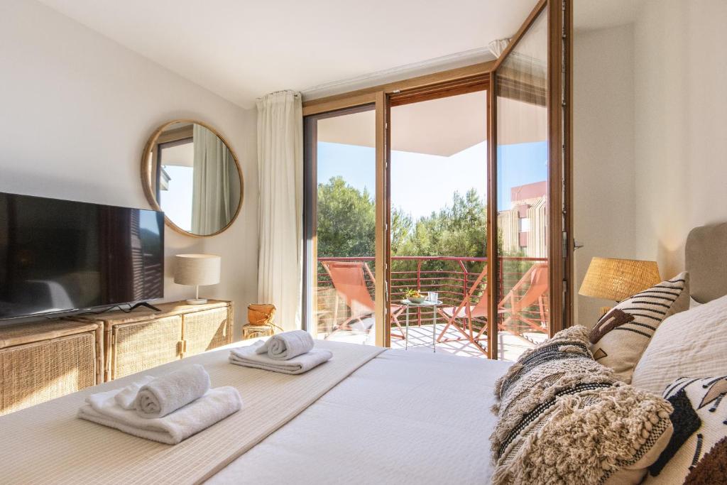 een slaapkamer met een bed en een tv en een balkon bij Cofisa Coral in Jávea