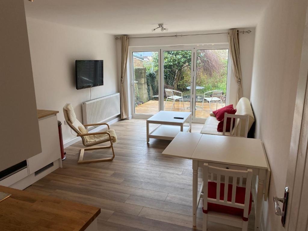 een woonkamer met een tafel en stoelen bij Adorable One-Bedroom Flat With Patio Garden. in Southwick