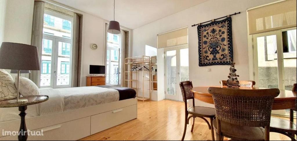 een slaapkamer met een bed en een tafel en stoelen bij Dom Luis apartment in Porto