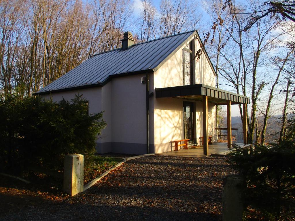 uma pequena casa branca com um telhado preto em l'abri'gîte sous les arbres em Huy