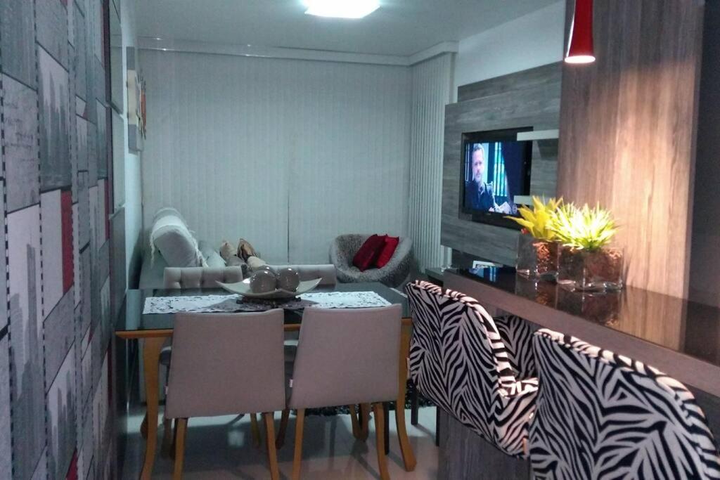 a dining room with a table and some chairs at Apartamento aconchegante em Bento Gonçalves, próximo ao vale dos vinhedos in Bento Gonçalves