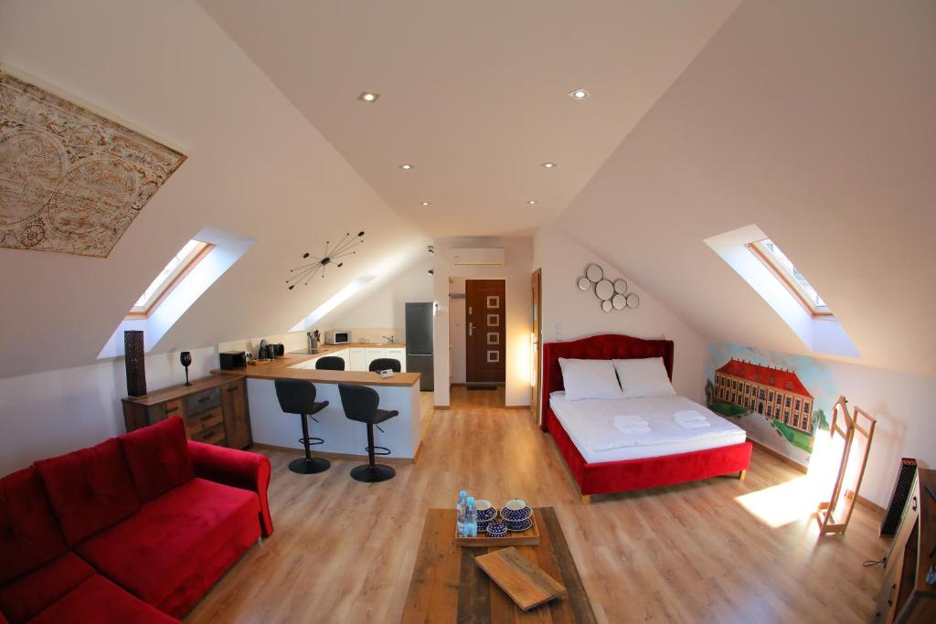 a attic bedroom with a bed and a couch at Apartament Książęcy klimatyzacja in Żagań