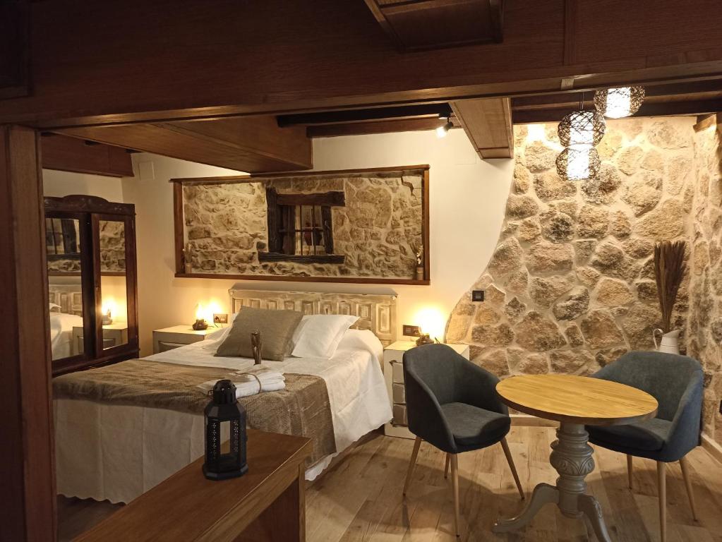 a bedroom with a bed and a table and chairs at El Cascanueces - Casa Rural in Candelario