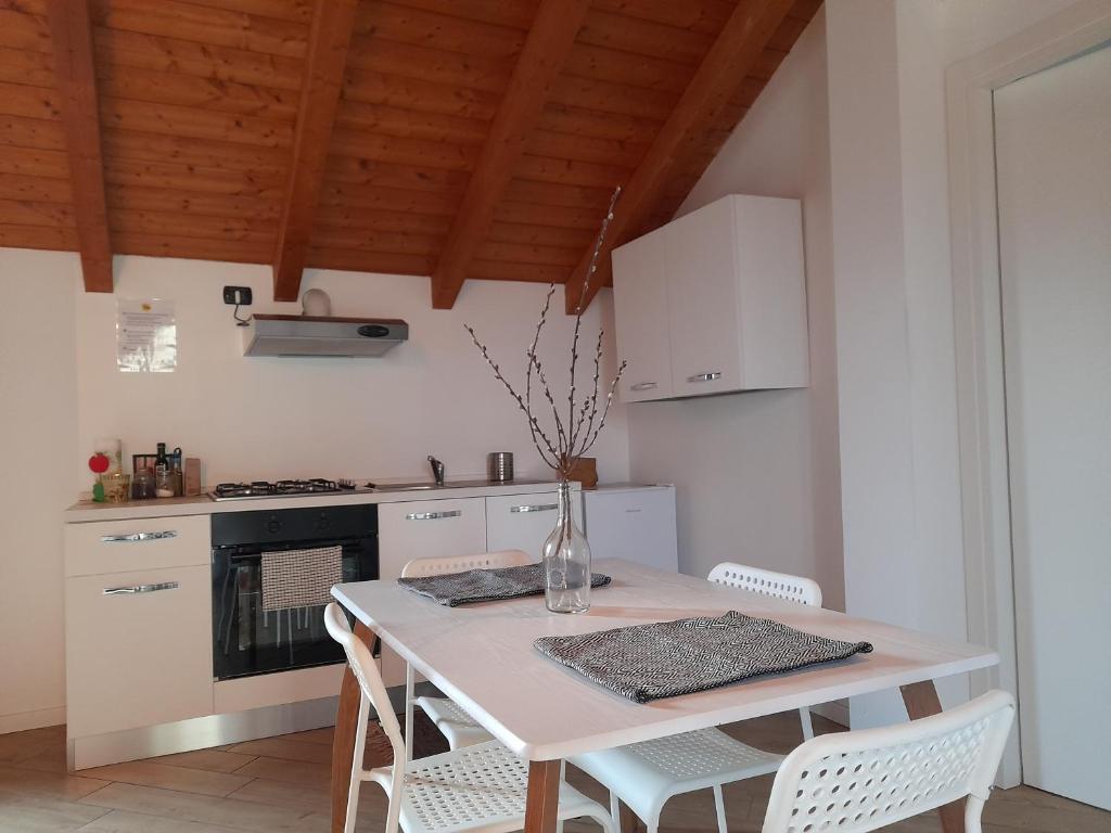 uma cozinha com uma mesa branca e electrodomésticos brancos em A Casa di Sole Arese em Arese