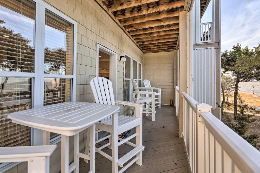 a porch with white chairs and a table at Ocean Club Condo with Community Pool and Hot Tub in Salter Path