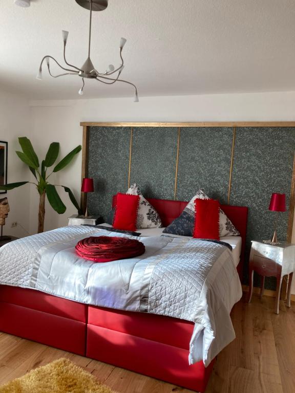 a bedroom with a large red bed with red pillows at Gaestehaus Klaus in Mendig