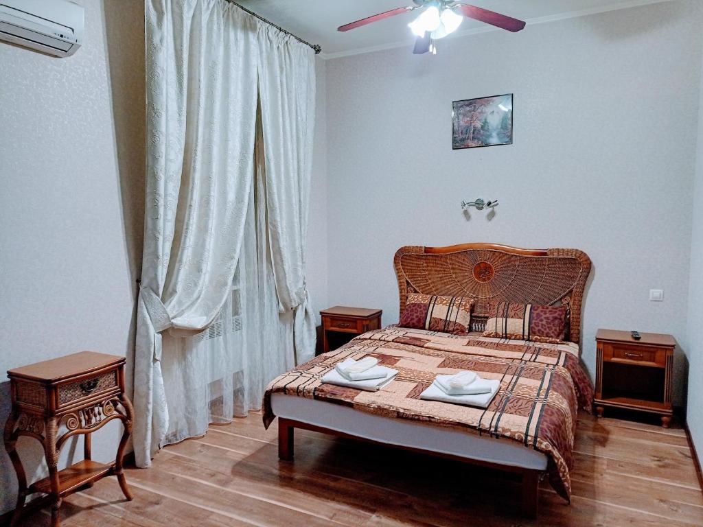 a bedroom with a bed with two tables and a window at Апартаменты в двух шагах от метро in Kharkiv