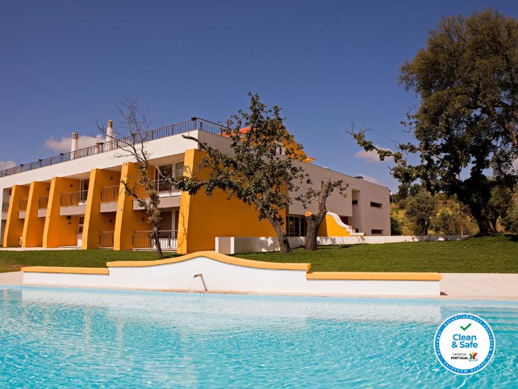 a swimming pool with a slide in front of a building at Cabecas do Reguengo in Portalegre