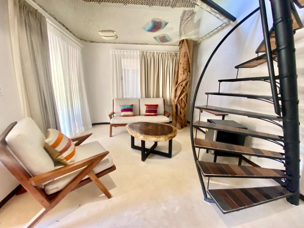 a living room with a spiral staircase and a couch at Hotel Circulo Bacalar in Bacalar