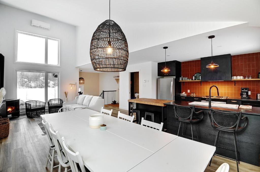 een keuken en een woonkamer met een grote witte tafel bij 01 Chemin des Cascades in Stoneham
