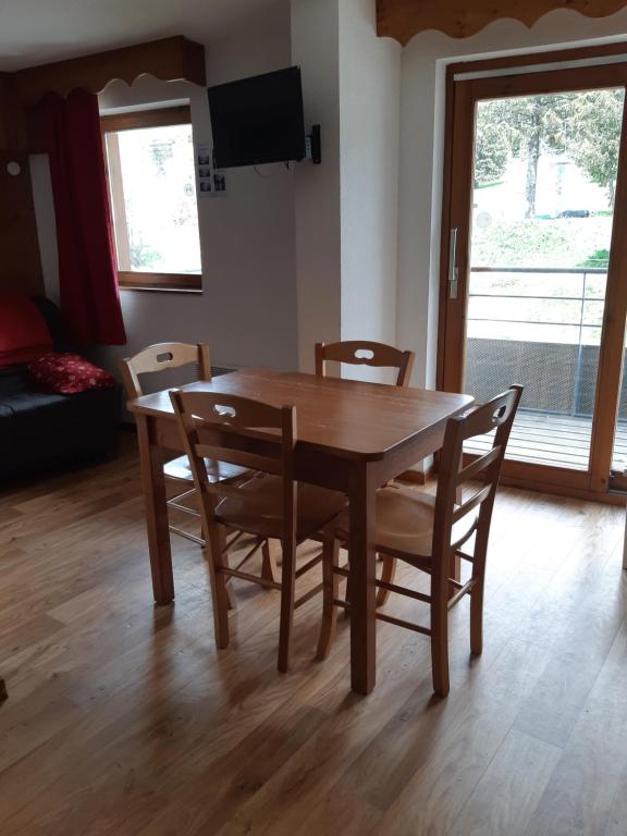 a wooden dining room table with chairs and a television at Chamrousse 1700 - Les Villages du Bachat -Droseras E23 - Au pied des pistes in Chamrousse