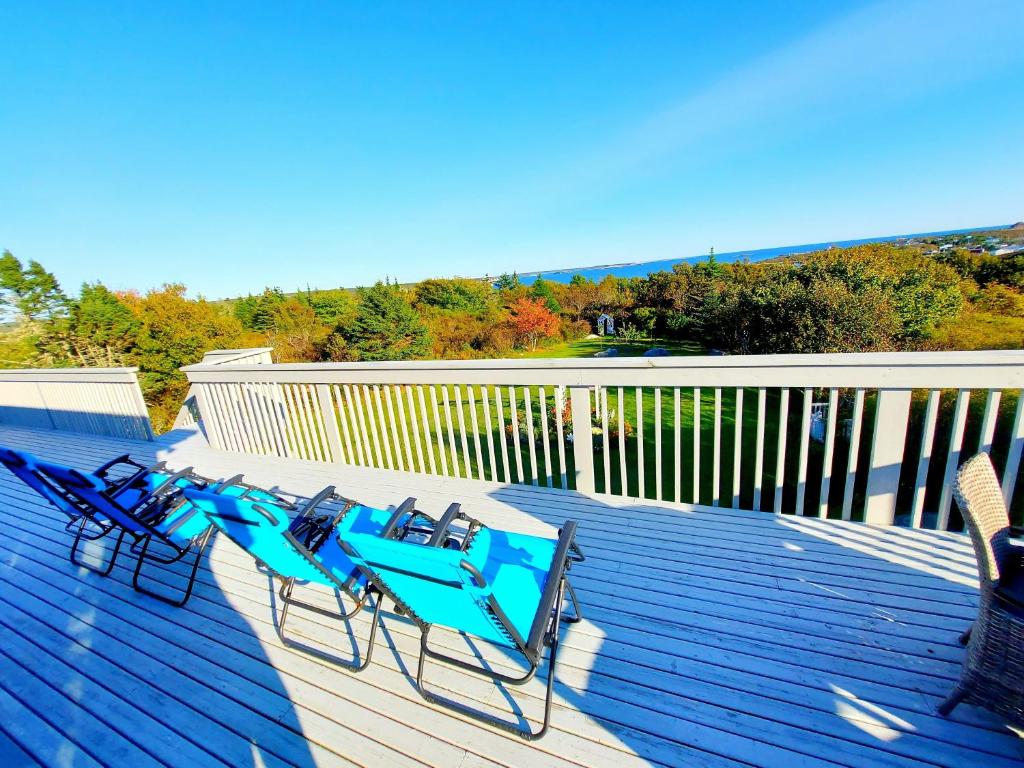 a group of blue lounge chairs on a deck at Sunrise vacation cottage in Terence Bay