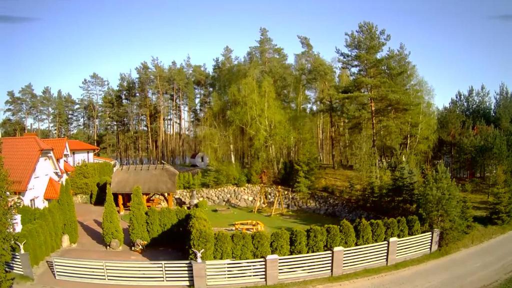 a garden with a white fence and trees at Agro Breza - dom z kominkiem 20 metrow od jeziora- sauna, balia ogrodowa in Lipusz