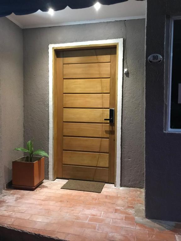 una puerta de madera con una planta delante en Hotel Mola en Puerto Iguazú