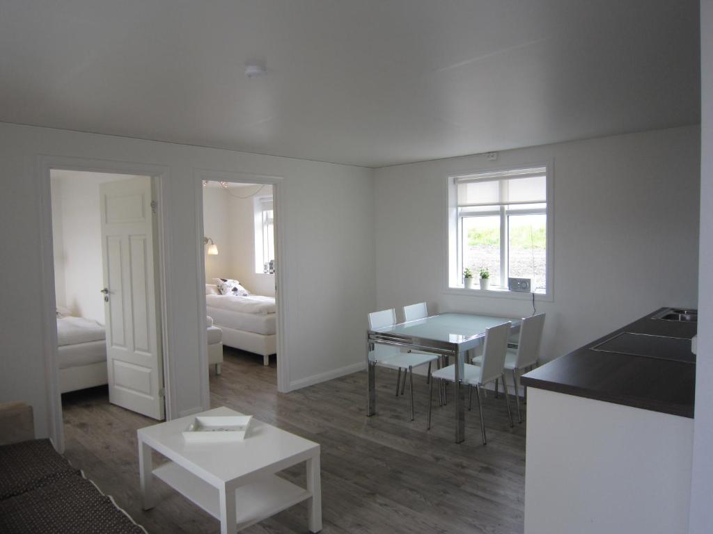 Apartment by the Sea في هوفن: مطبخ وغرفة معيشة مع طاولة وكراسي