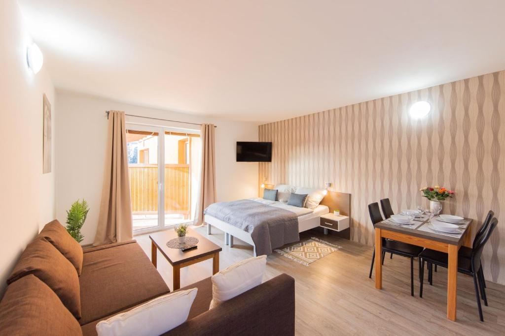 ein Hotelzimmer mit einem Bett und einem Wohnzimmer in der Unterkunft Apartmán Sophia 2 in Velké Losiny