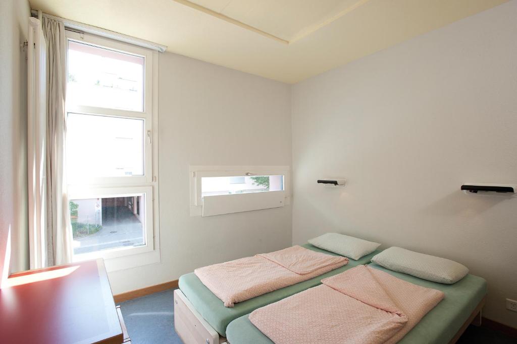 Postel nebo postele na pokoji v ubytování Zurich Youth Hostel