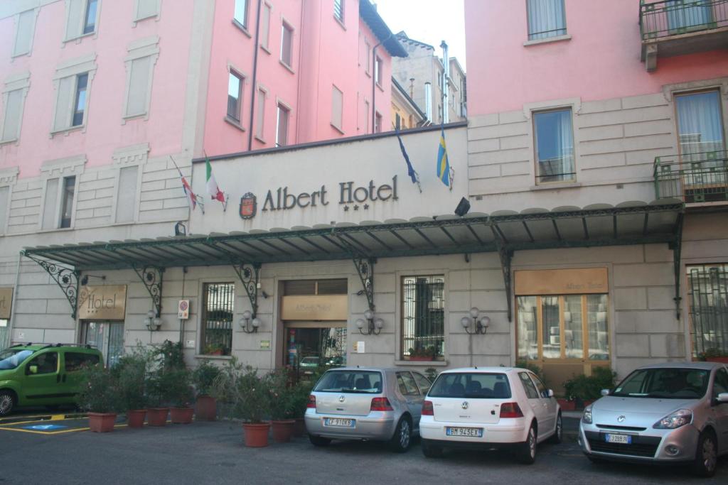 un bâtiment avec des voitures garées devant lui dans l'établissement Albert Hotel, à Milan