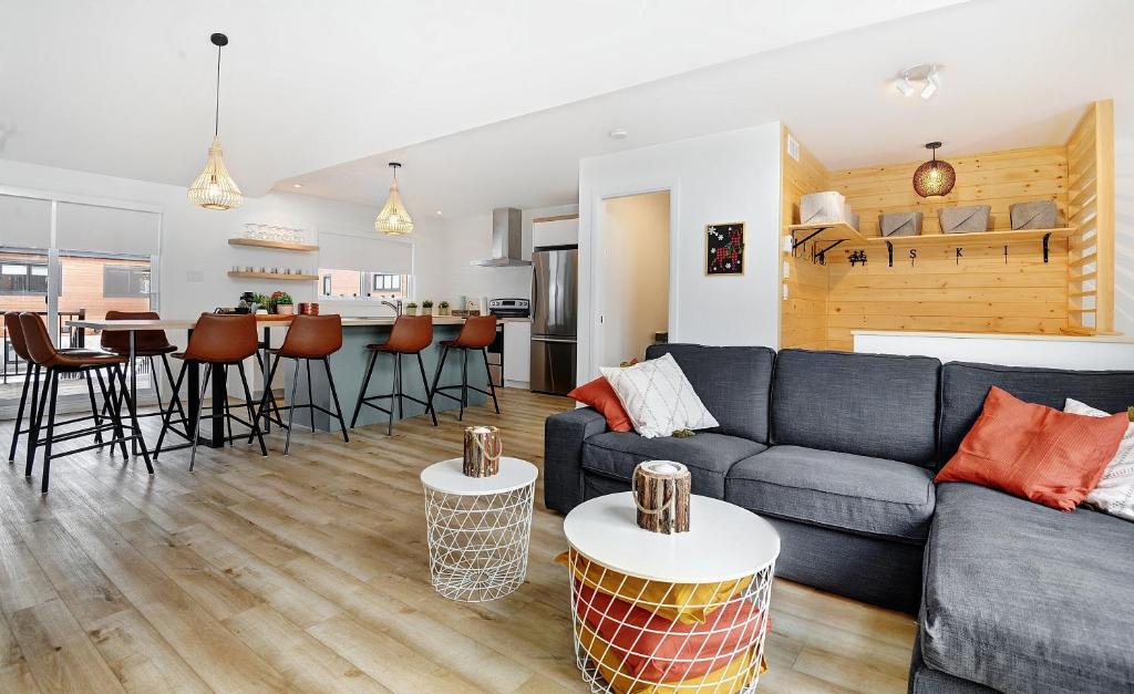 Una sala de estar y una cocina con un sofá y una mesa. en 110 Chemin des Ruisselets, en Stoneham