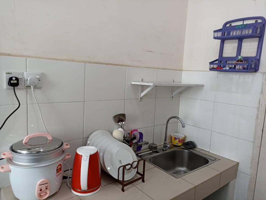 a small kitchen with a sink and a counter top at Homestay uuc in Kota Kinabalu