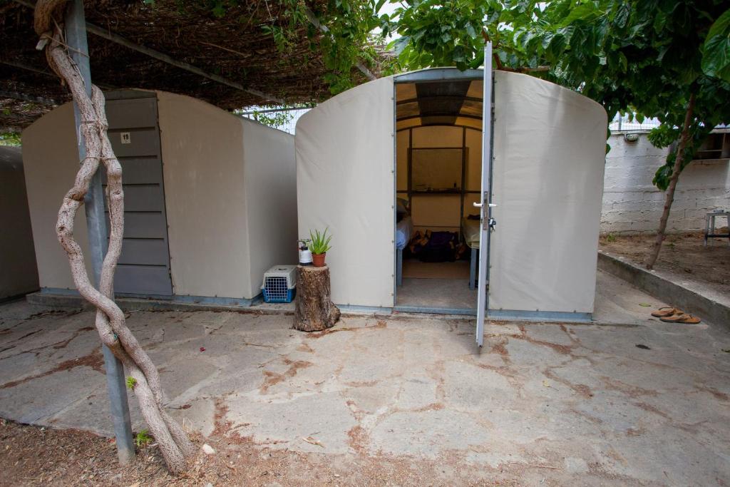 an entrance to a white building with a tree at Camping Koula in Parikia