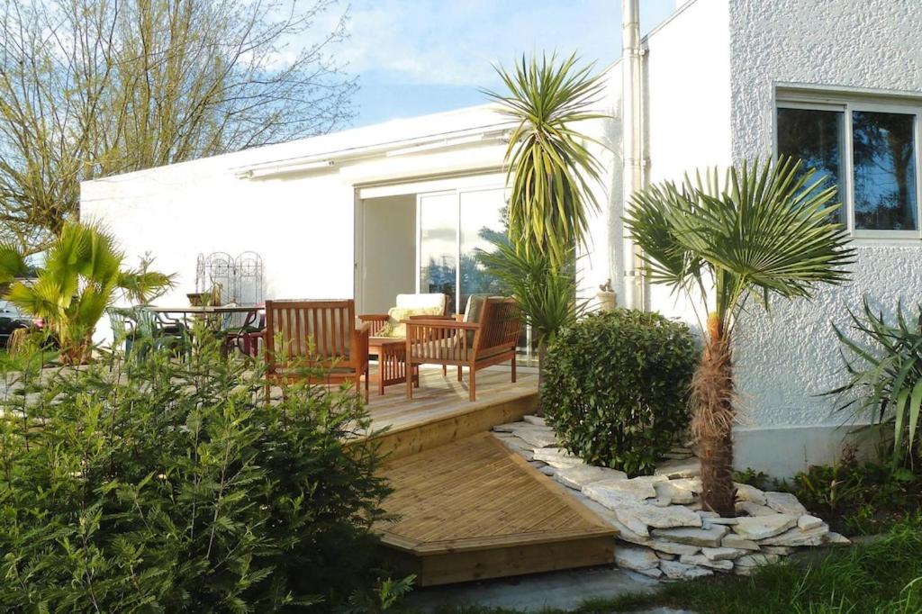 un patio con una mesa, sillas y una palmera en holiday home with indoor pool, Le Porge en Le Porge