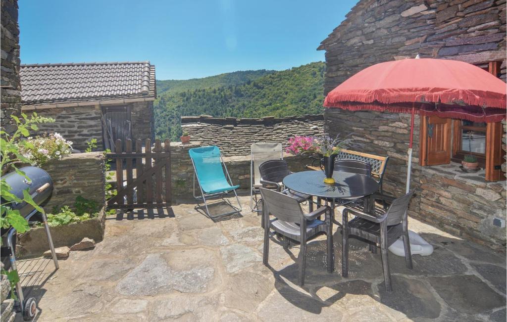 a patio with a table and chairs and an umbrella at 2 Bedroom Gorgeous Home In Bonnevaux in Bonnevaux-et-Hiverne