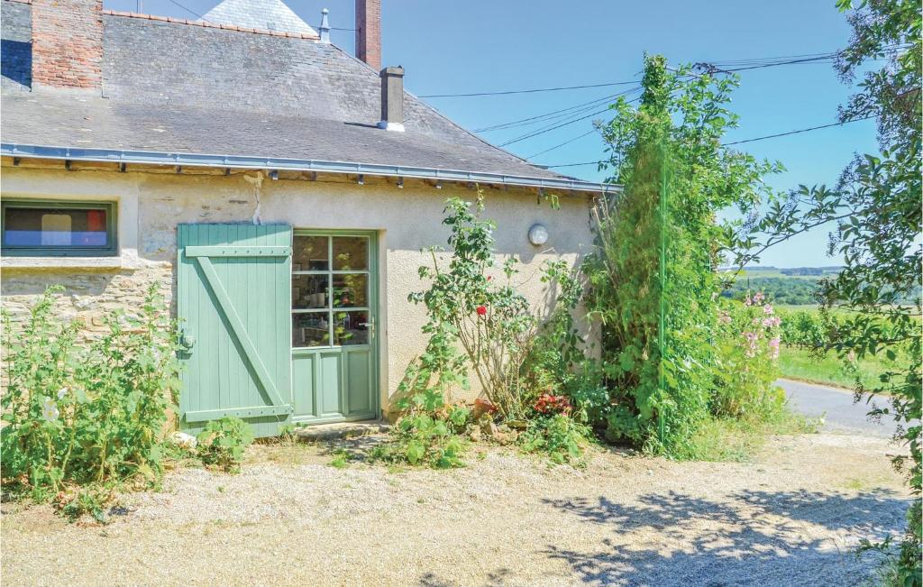 un ancien cottage en pierre avec une porte verte dans l'établissement Amazing Home In St Jean Des Mauvrets With 2 Bedrooms, à Saint-Mélaine-sur-Aubance