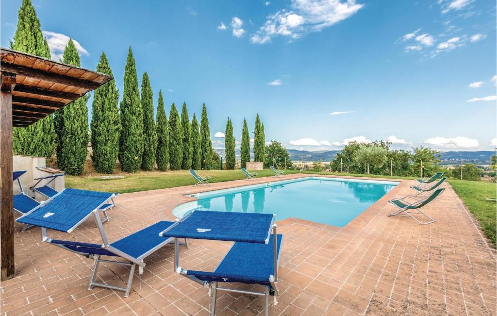 - une piscine avec des chaises bleues et une table dans l'établissement Seranna 3, à Papiano