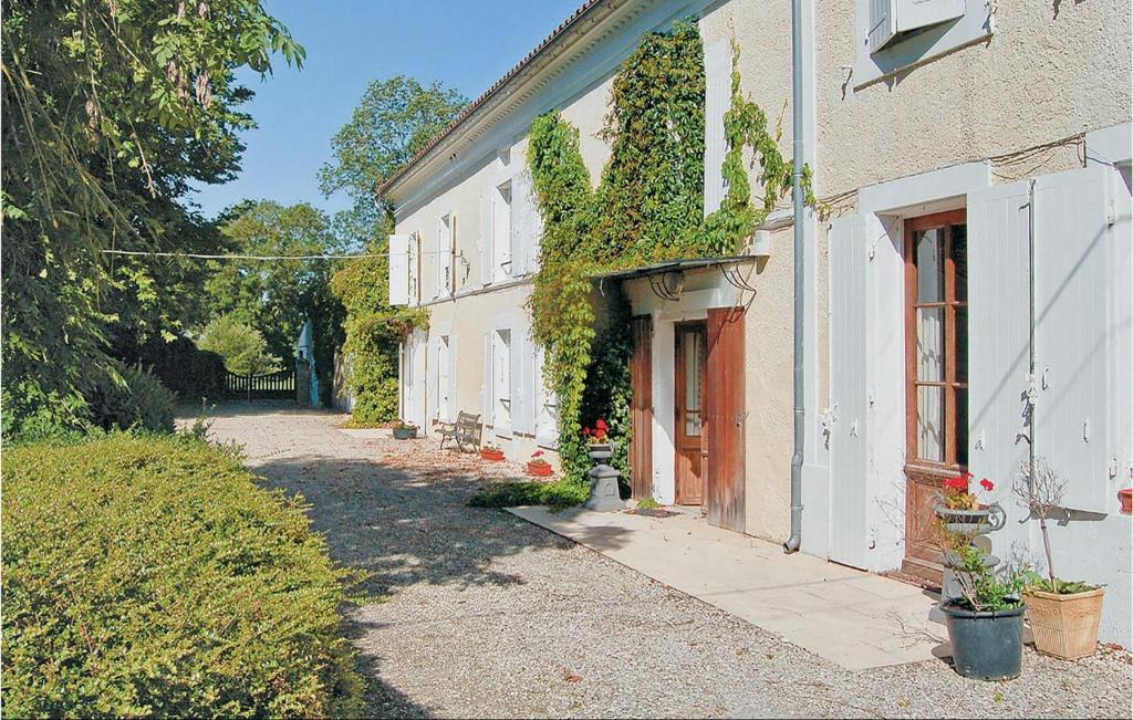 a white house with ivy growing on the side of it at Nice Home In Cresse With Kitchen in Cressé